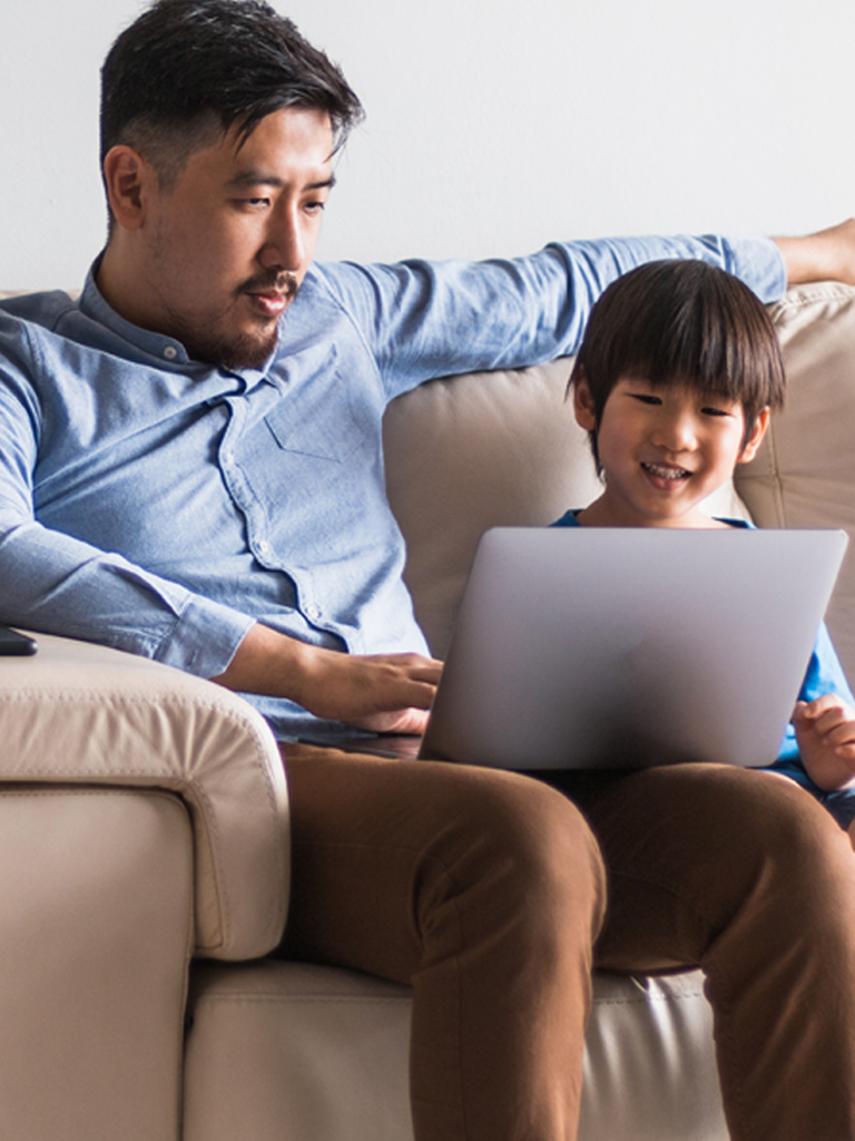 Man working with son on computer.