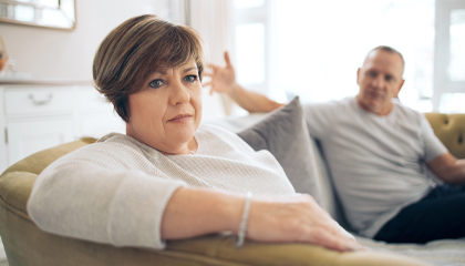 Couple sitting couch having discussion.