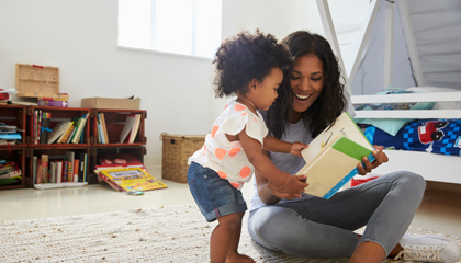 Mother and toddler daughter reading.