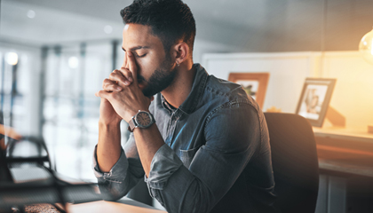 Man sitting with head in hands.