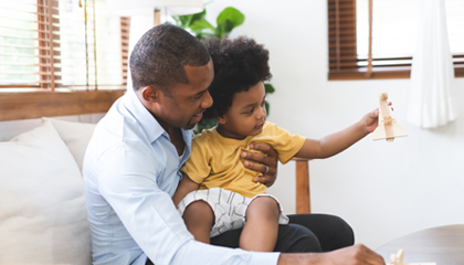 Man holding son on lap.