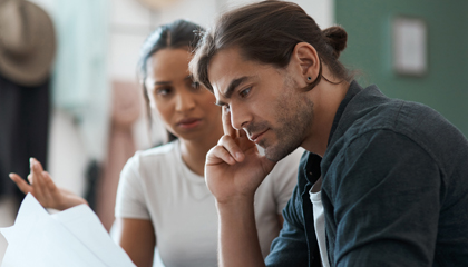 Couple having serious discussion while looking at paperwork.