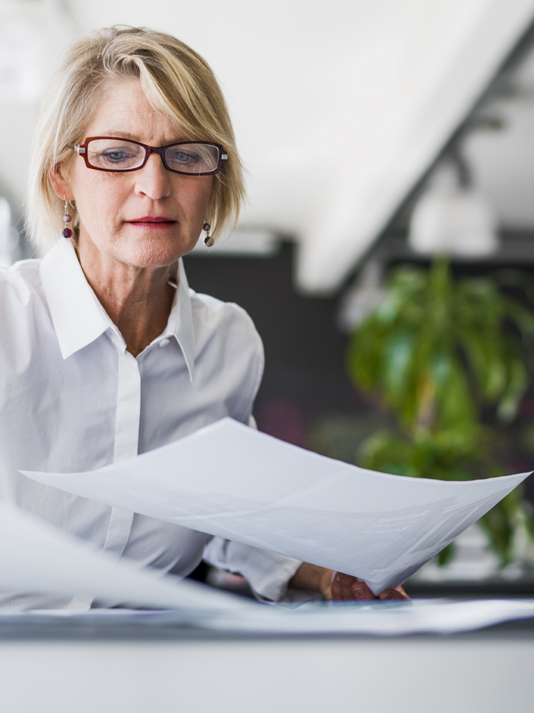 Business woman working on documents at desk.