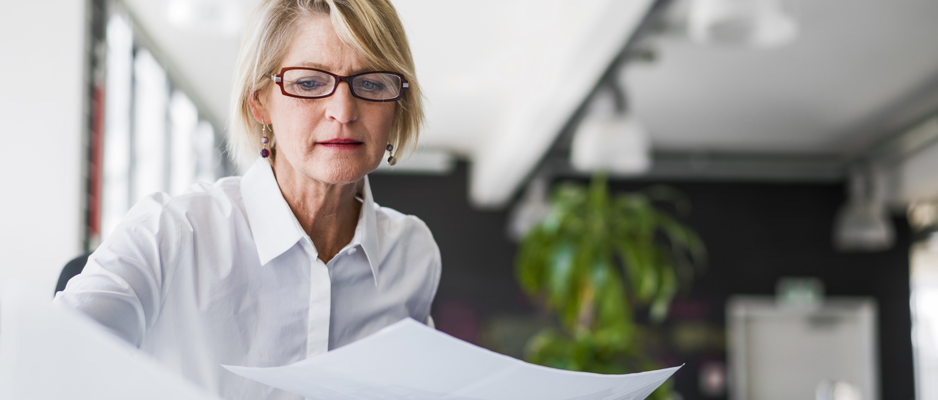 Woman sitting at table reviewing paper work.