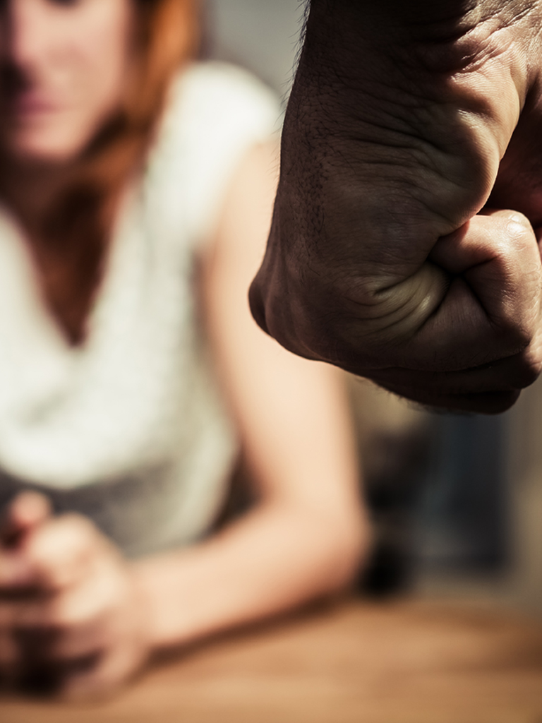 Image of mans fist with woman in background.