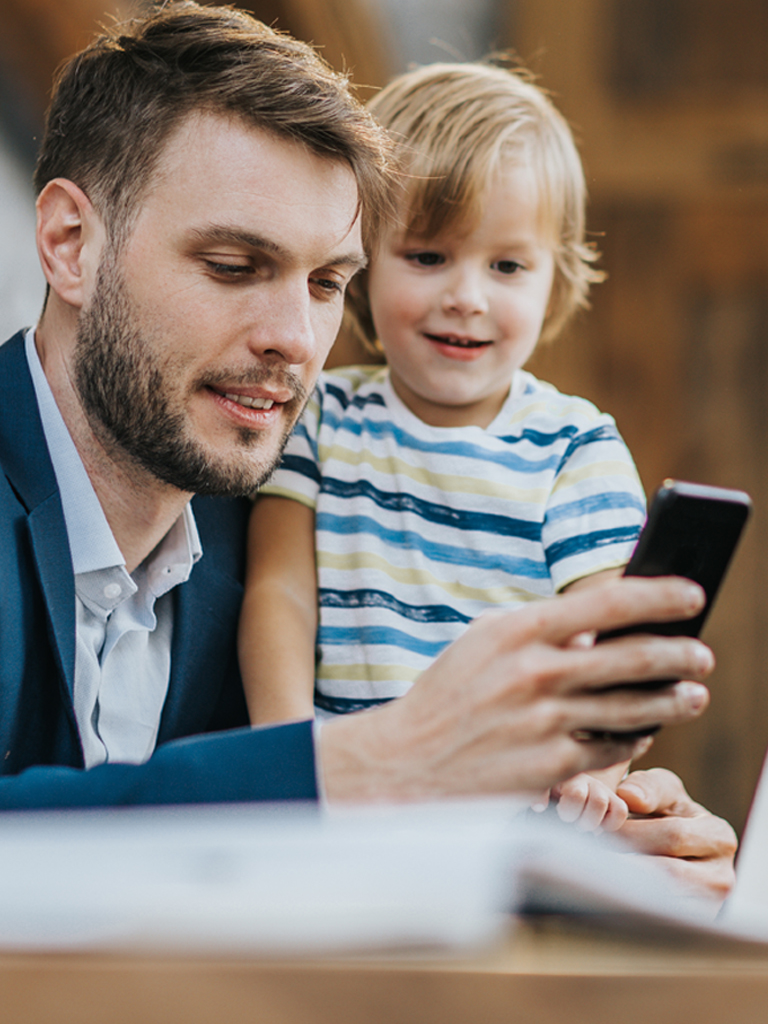 Father and young son looking at mobile phone.